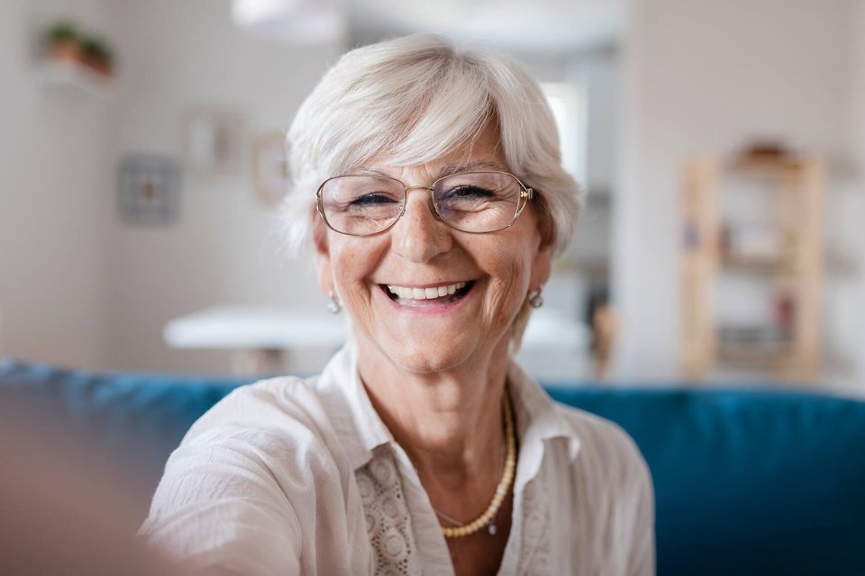 Grandma Taking Selfies at Home in the Livingroom. Close Up Portrait of Happy Cheerful Delightful Charming Beautiful Elderly Lady Granny Grandma Taking a Selfie. Old-Age, Retirement and People Concept
