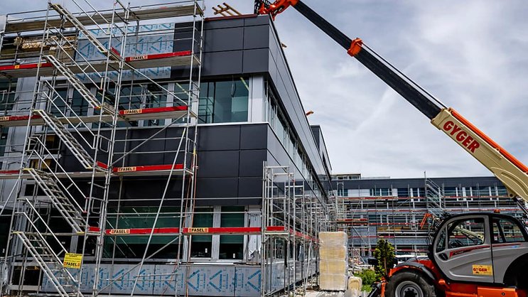Des bâches recouvrent le chantier de l'entreprise Sellita Watch en reconstruction, une année après la tempête