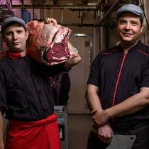Frédéric (tablier rouge) et Grégory Perusset, les deux frères à la tête de la boucherie Perusset, font rayonner leur savoir-faire dans le Nord vaudois dans la joie, la bonne humeur et l’amour de la tradition.