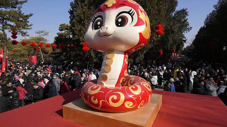 Un serpent, symbole de l'année qui commence, devant un temps à Pékin.