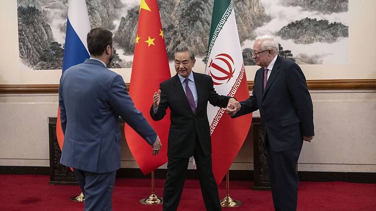 Le chef de la diplomatie chinoise Wang Yi (au centre) accueille les vice-ministres des affaires étrangères iranien et russe.