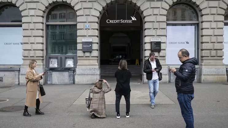 Des gens prennent des photos de la banque Credit Suisse à la Paradeplatz de Zurich. La direction prévoit de verser tous les bonus comme prévu.