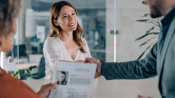 Un recruteur serrant la main d'une candidate après un entretien d'embauche