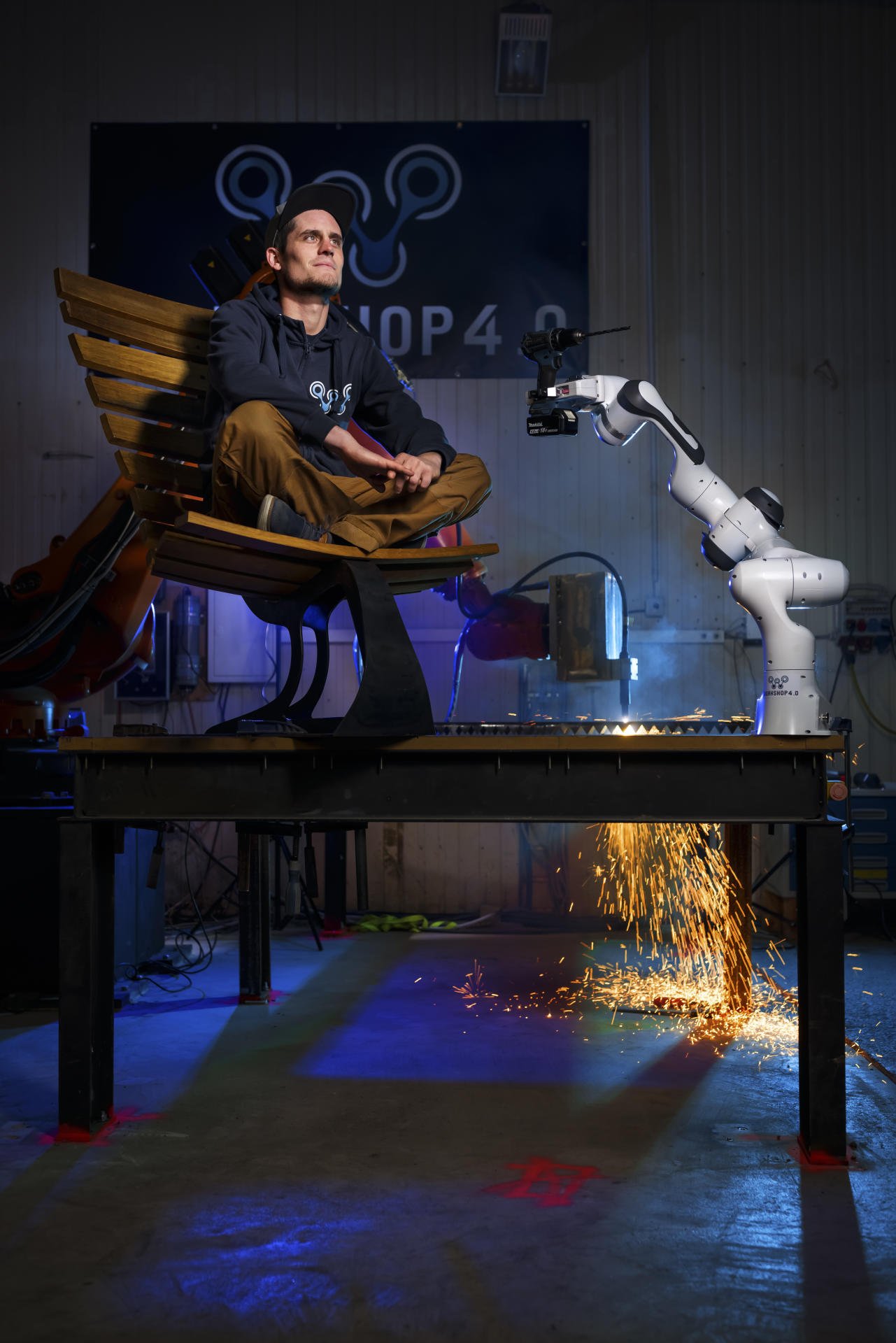 Nicolas Fontaine pose assis sur un siege fabrique avec des tonneaux de vin alors qu'un robot decoupe de l'acier avec une toche au plasma dans le fond, le lundi 30 novembre 2020 dans le local de son "Workshop 4.0" a Sierre. (VFLPIX.COM /Valentin Flauraud)
Les jeunes qui feront la Suisse de demain