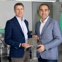 Le CEO du CSEM, Alexandre Pauchard, et le CEO de CCRAFT, Hamed Sattari, tiennent un wafer TFLN entre les mains.