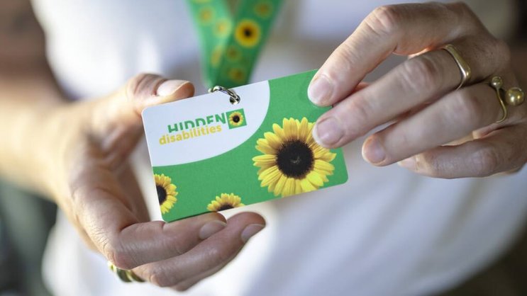 Après les CFF dans certaines gares, l'aéroport de Zurich introduit à son tour la possibilité pour les personnes souffrant d'un handicap non visible de porter un cordon vert à motifs de tournesols autour du cou.