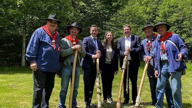 Le conseiller fédéral Albert Roesti pose avec le conseiller d'Etat vaudois Vassilis Venizelos et la conseillère municipale de la ville de Lausanne Natacha Litzistorf, entourés des Brigands du Jorat.