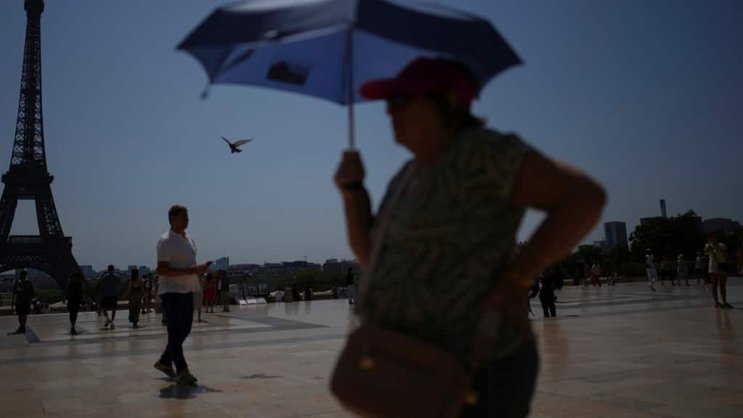 Un touriste s'abrite du soleil avec une ombrelle, sur le Trocadero à Paris, lors d'un épisode caniculaire de juillet. (image d'illustration)