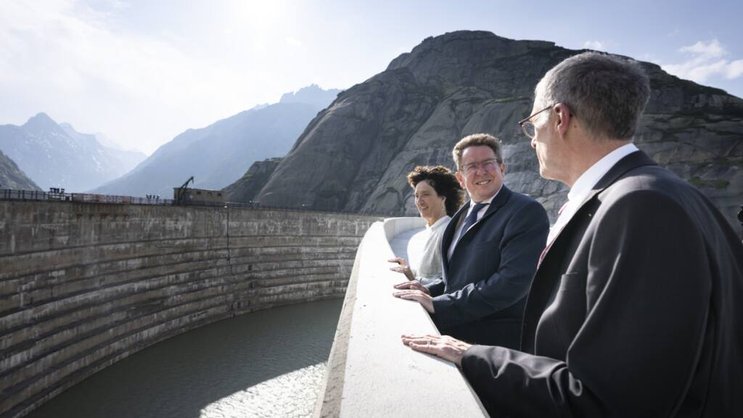 Barbara Egger-Jenzer présidente du conseil d'administration des KWO (gauche), le conseiller fédéral Albert Roesti (centre) et Daniel Fischlin CEO des KWO se tiennent sur le nouveau barrage de Spitallamm, haut de 113 mètres au lac du Grimsel vendredi.