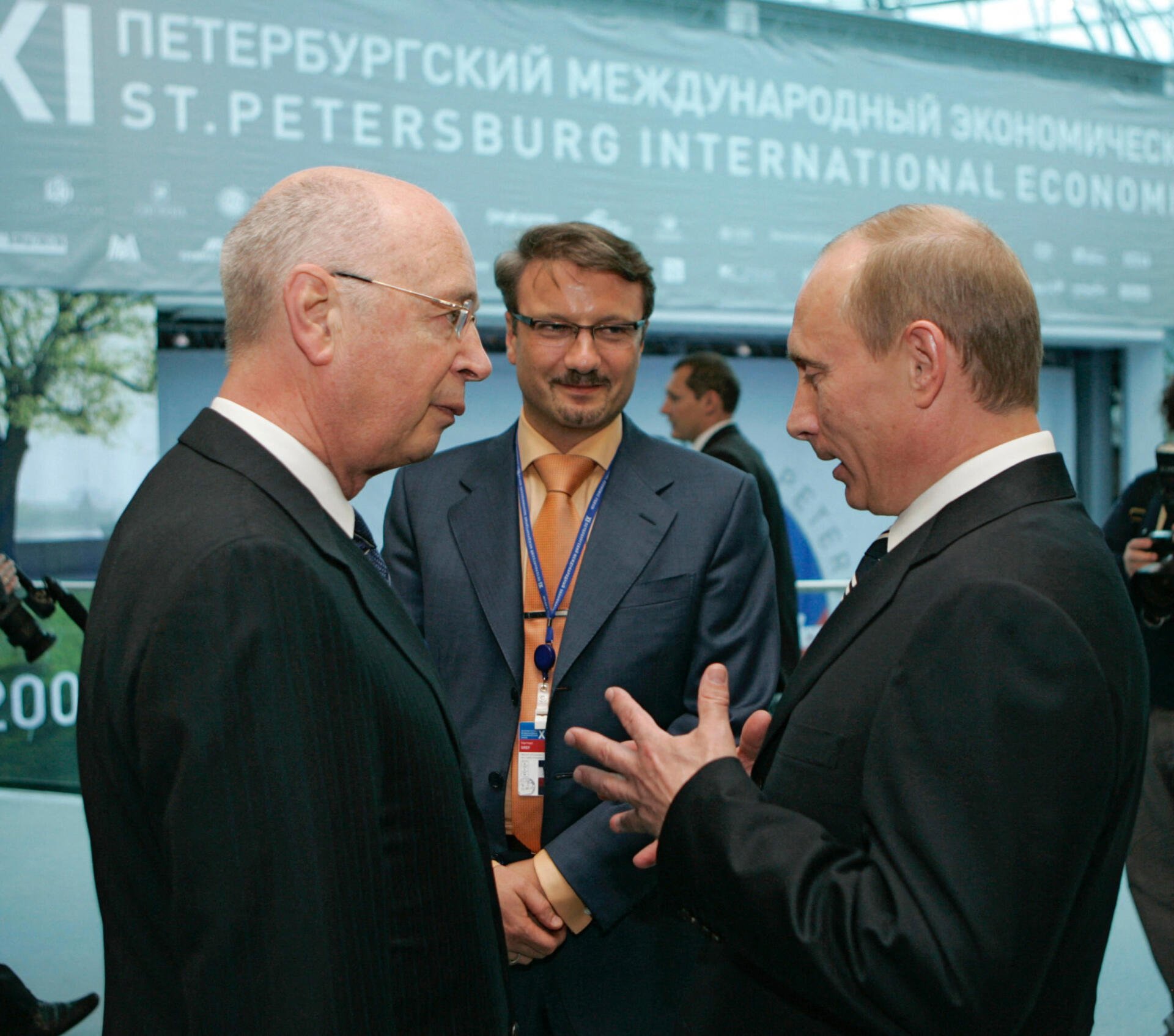 President of the World Economic Forum in Davos Klaus Schwab (L) speaks with Russian President Vladimir Putin (R) as Russian Economic Development and Trade Minister German Gref (background) looks at them after a meeting with representatives of foreign companies during the 11th St. Petersburg International Economic Forum in St.Petersburg, 09 June 2007. AFP PHOTO / KREMLIN POOL (Photo by DMITRY ASTAKHOV / POOL / AFP)