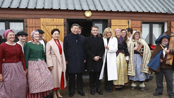 Emmanuel Macron et Xi Jinping, accompagnés de leurs épouses, prennent la pose avec des danseurs traditionnels.