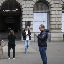 Des gens prennent des photos de la banque Credit Suisse à la Paradeplatz de Zurich. La direction prévoit de verser tous les bonus comme prévu.