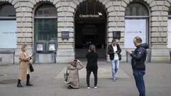 Des gens prennent des photos de la banque Credit Suisse à la Paradeplatz de Zurich. La direction prévoit de verser tous les bonus comme prévu.